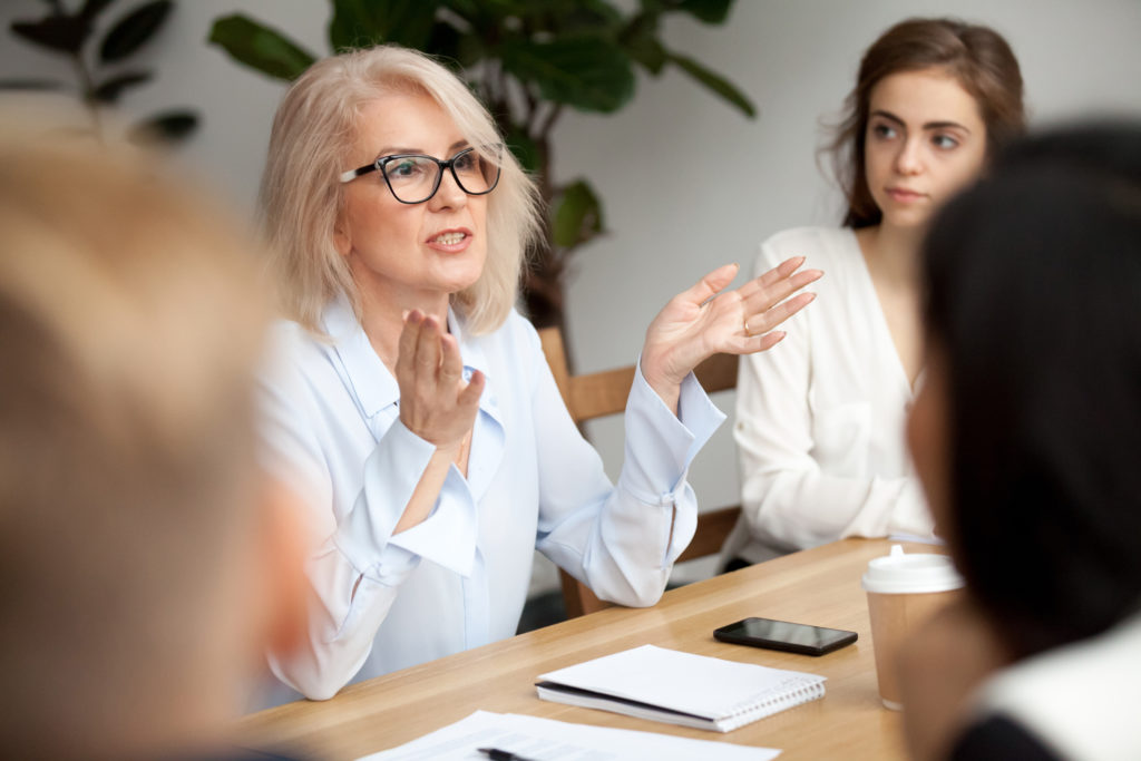 Older woman imparting wisdom to younger co-worker