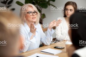 Elder woman in workplace sharing wisdom